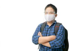 asiatisk pojke studerande ha på sig ansikte skydda och mask bär skola väska isolerat foto