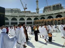 mecka, saudi Arabien, april 2023 - pilgrimer från annorlunda länder av de värld är utför tawaf i de gård av masjid al-haram i mecka under de dag. foto