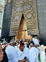 mecka, saudi Arabien, april 2023 - umrah pilgrimer från Allt över de värld samla i de gård av masjid al-haram nära de dörr av de kaaba. foto