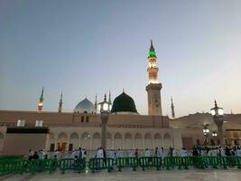 medina, saudi Arabien, Maj 2023 - skön morgon- se av masjid al nabawi, medina. besökare, gårdar utanför de moské, skön lampor, och elektronisk paraplyer kan också vara sett. foto