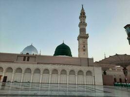 skön morgon- se av masjid al nabawi, medinas grön kupol, minareter och moské gård. foto