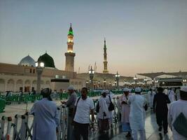 medina, saudi Arabien, Maj 2023 - skön morgon- se av masjid al nabawi, medina. besökare, gårdar utanför de moské, skön lampor, och elektronisk paraplyer kan också vara sett. foto