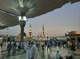 medina, saudi Arabien, Maj 2023 - skön morgon- se av masjid al nabawi, medina. besökare, gårdar utanför de moské, skön lampor, och elektronisk paraplyer kan också vara sett. foto