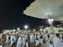 medina, saudi Arabien, Maj 2023 - skön natt tid se av masjid al nabawi, medina. besökare, gårdar utanför de moské, skön lampor och elektronisk paraplyer kan också vara sett. foto