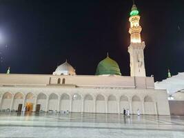 medina, saudi Arabien, Maj 2023 - skön se av masjid al nabawi, medina, hög minareter och moské på natt. de moské presenterar en skön scen i de natt lampor. foto