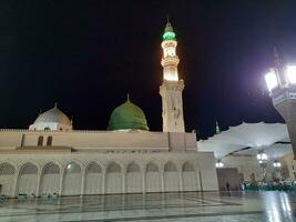 medina, saudi Arabien, Maj 2023 - skön se av masjid al nabawi, medina, hög minareter och moské på natt. de moské presenterar en skön scen i de natt lampor. foto