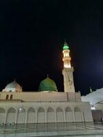 medina, saudi Arabien, Maj 2023 - skön se av masjid al nabawi, medina, hög minareter och moské på natt. de moské presenterar en skön scen i de natt lampor. foto