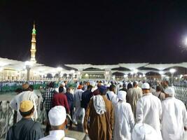 medina, saudi Arabien, Maj 2023 - skön natt tid se av masjid al nabawi, medina. besökare, gårdar utanför de moské, skön lampor och elektronisk paraplyer kan också vara sett. foto