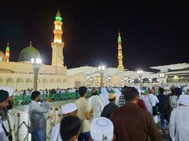 medina, saudi Arabien, Maj 2023 - skön natt tid se av masjid al nabawi, medina. besökare, gårdar utanför de moské, skön lampor och elektronisk paraplyer kan också vara sett. foto