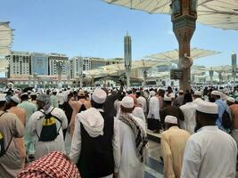 medina, saudi Arabien, Maj 2023 - en skön dagtid se av masjid al nabawi, medinas yttre gård, pilgrimer och moské baldakiner. foto