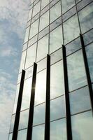 modern kontor byggnad med glas Fasad och blå himmel. företag bakgrund. modern arkitektur i de stad foto