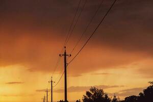 högspänning kraft rader på solnedgång. elektricitet distribution station. elektricitet pyloner på de bakgrund av de himmel foto