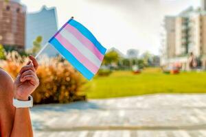 kön queer. kvinna hand innehav trans flagga. selektiv fokus. foto