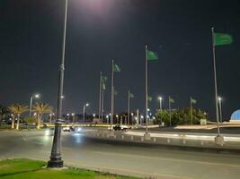 jeddah, saudi Arabien, juni 2023 - en skön se av saudi arab flaggor flygande på jeddah corniche väg genomskärning på natt. foto