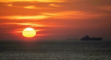 solnedgång i virginia strand med frakt fartyg n distans foto
