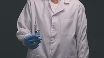 läkaren höll en flaska vaccinmedicin och en medicinsk spruta foto