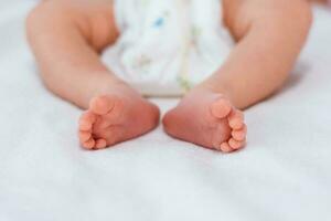 nyfödd bebis fötter på vit filt. maternity och barndom begrepp. foto
