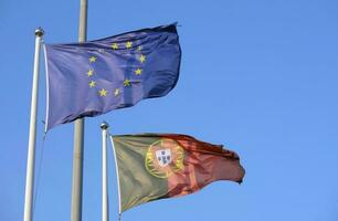 portugisiska nationell flagga och flagga av de europeisk union vinka i de vind foto