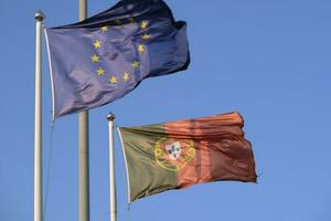 portugisiska nationell flagga och flagga av de europeisk union vinka i de vind foto