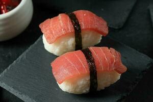 hemlagad nigiri tonfisk sushi på svart skiffer tallrik foto