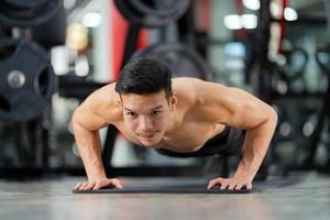 sportig man utbildning gör push ups på gymmet foto