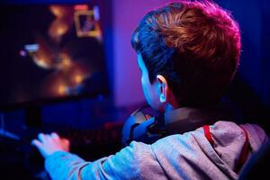 pojke spelar dator spel på Hem, gaming missbruk foto