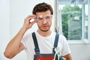 porträtt av Hem reparera arbetstagare. renovering hantlangare med skyddande glasögon och respirator foto