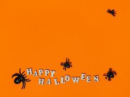 halloween dekorationer på ett orange bakgrund med de inskrift Lycklig halloween och spindlar. platt layout, kopia Plats foto