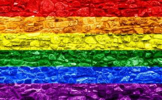 flagga av de HBTQ gemenskap på de bakgrund av en sten vägg. regnbåge symbol av Gay kultur. begrepp collage. illustration symbol av stolthet. foto