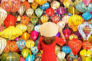 Lycklig kvinna bär ao dai vietnamese klänning med färgrik lyktor, resande sightseeing på hoi ett gammal stad i central vietnam.landmark för turist attraktioner.vietnam och sydöst resa begrepp foto