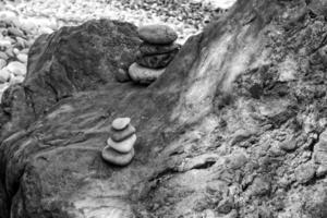 intressant torn tillverkad av stenar anordnad på de Strand av de hav på en värma sommarens dag foto