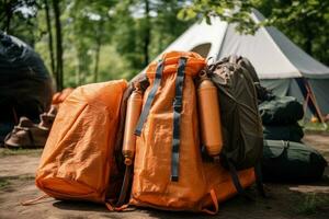 camping Utrustning i de skog. ryggsäck och tält på bakgrund. resa påsar i främre av en camping tält vandring redskap, ai genererad foto