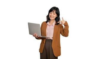 skön ung asiatisk kvinna på kontor Kläder innehav bärbar dator pc dator och ser på kamera med leende ansikte och punkt finger till henne arbete, isolerat på vit bakgrund foto
