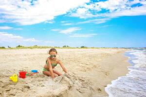 barn spelar med sand på strand. foto