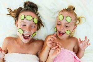 skön flicka med ansiktsbehandling mask av gurka. foto