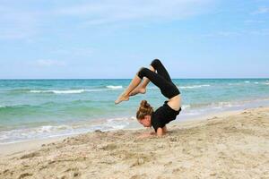 flicka håller på med sporter övningar på de strand. foto
