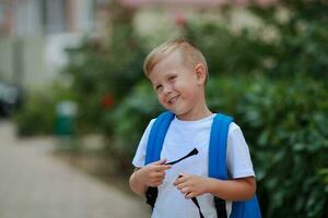 porträtt av en pojke med en portfölj på de gata. tillbaka till skola. foto