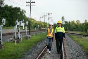 asiatisk järnväg ingenjör inspekterar en tåg station ingenjör arbetssätt på underhåll inspektion i järnväg station foto