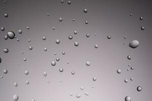 droppar av vatten på en transparent grå bakgrund. foto