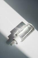 en vit transparent flaska med serum i de strålar av de Sol. foto