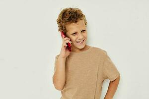 glad söt pojke med telefon i händer Framställ teknologi foto