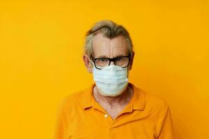 porträtt av Lycklig senior man medicinsk mask i en gul skjorta svartvit skott foto