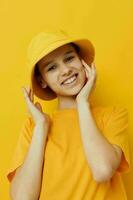 ung kvinna i en gul hatt ungdom stil tillfällig ha på sig isolerat bakgrund foto