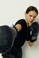 Foto Söt flicka i svart sporter enhetlig boxning handskar Framställ livsstil oförändrad