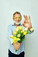 porträtt av Lycklig senior man en bukett av blommor med glasögon som en gåva oförändrad foto