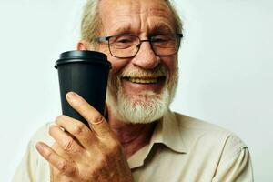 leende man innehav en glas av kaffe på en ljus bakgrund foto