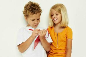 söt förskola barn roligt i färgrik t-tröjor med en anteckningsblock Färg bakgrund oförändrad foto
