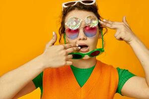 rolig flicka orange tröjor solglasögon flerfärgad glasögon tillförsel gul bakgrund oförändrad foto
