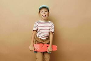 Söt ung flicka skateboard i hand Framställ bebis kläder roligt isolerat bakgrund foto