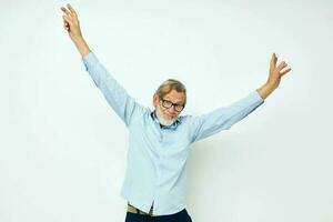 senior gråhårig man i blå shirts gester med hans händer isolerat bakgrund foto